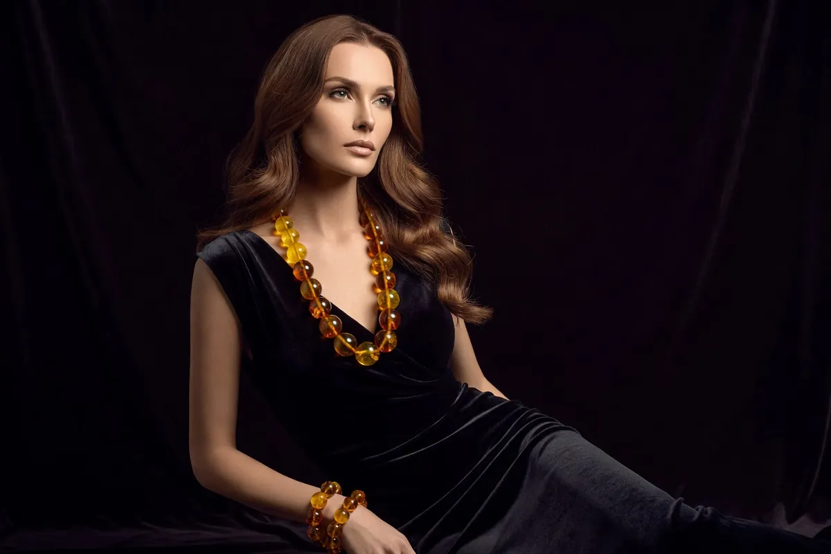Femme balte portant un lourd collier de perles d'ambre jaune doré et cognac